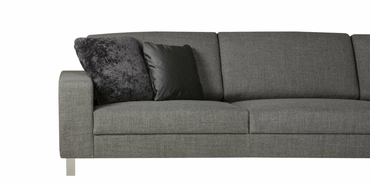 Le canapé gris chic, avec des pieds en métal élégants, comporte deux coussins, un noir et un gris foncé avec une finition texturée, sur fond blanc immaculé. Canape Paris by Atelier Bis