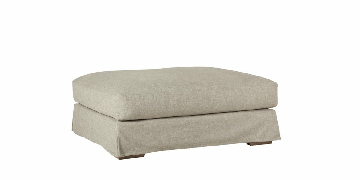 Pouf carré gris clair avec un dessus rembourré et une jupe en tissu, capturant l'essence de l'élégance parisienne sur fond blanc. Canape Paris by Atelier Bis