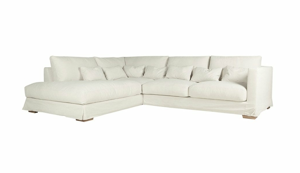 L'élégant canapé blanc en forme de L, orné de multiples coussins, évoque la qualité parisienne sur un fond immaculé. Canape Paris by Atelier Bis