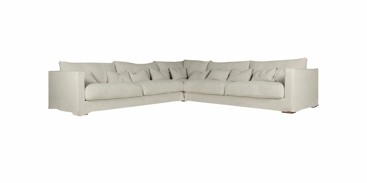 Un grand canapé beige en forme de L avec plusieurs coussins sur fond blanc présente une qualité exquise. Canape Paris by Atelier Bis