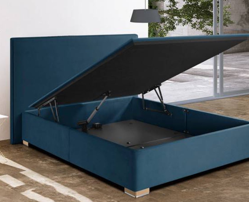 Un lit de rangement bleu sarcelle avec un mécanisme de levage hydraulique ouvert orne la pièce ensoleillée, rappelant un appartement parisien avec de grandes fenêtres qui invitent la tranquillité et le style dans ce havre de qualité. Canape Paris by Atelier Bis