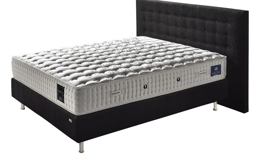 Un lit king-size avec un matelas blanc matelassé et une tête de lit capitonnée noire offre une qualité inégalée. Canape Paris by Atelier Bis