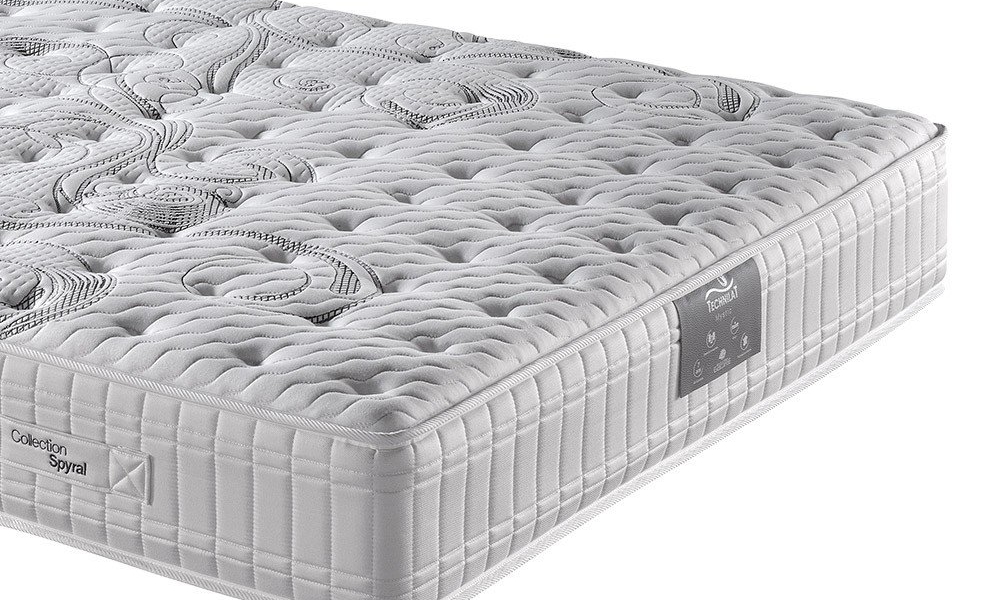 Gros plan d'un matelas blanc brodé avec une surface texturée et un motif subtil, reflétant un savoir-faire de la plus haute qualité. Canape Paris by Atelier Bis