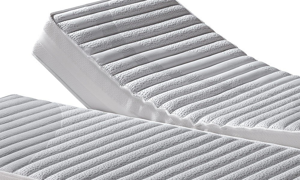 Lit modulable avec matelas gris à nervures, partiellement surélevé, offrant qualité et confort rappelant le style parisien. Canape Paris by Atelier Bis