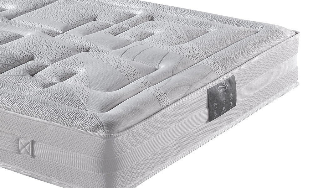 Gros plan d'un matelas matelassé blanc avec des motifs texturés et une étiquette en tissu sur le côté, mettant en valeur sa qualité. Canape Paris by Atelier Bis