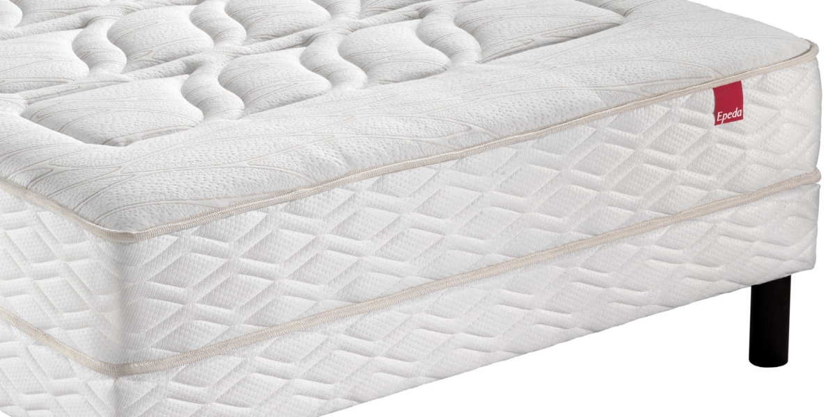 Matelas blanc sur pieds noirs avec un motif de losanges texturé, rappelant l'élégance parisienne, arborant une étiquette rouge frappante sur le côté. Canape Paris by Atelier Bis