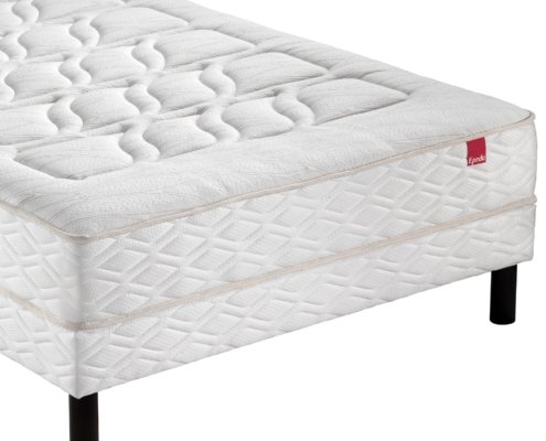 Matelas blanc sur pieds noirs avec un motif de losanges texturé, rappelant l'élégance parisienne, arborant une étiquette rouge frappante sur le côté. Canape Paris by Atelier Bis