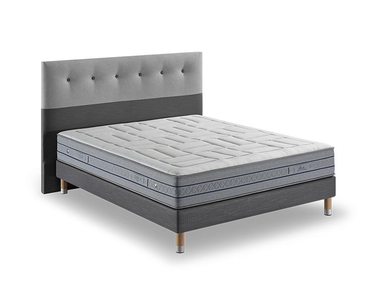 Cet élégant lit rembourré gris est doté d'une tête de lit capitonnée et d'un matelas gris clair sur son cadre en bois, offrant un mélange de style et de qualité rappelant la décoration parisienne chic. Canape Paris by Atelier Bis