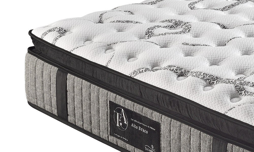 Gros plan d'un matelas moelleux à motifs avec un panneau latéral en tissu et des détails brodés sur la surface supérieure, mettant en valeur la qualité parisienne. Canape Paris by Atelier Bis