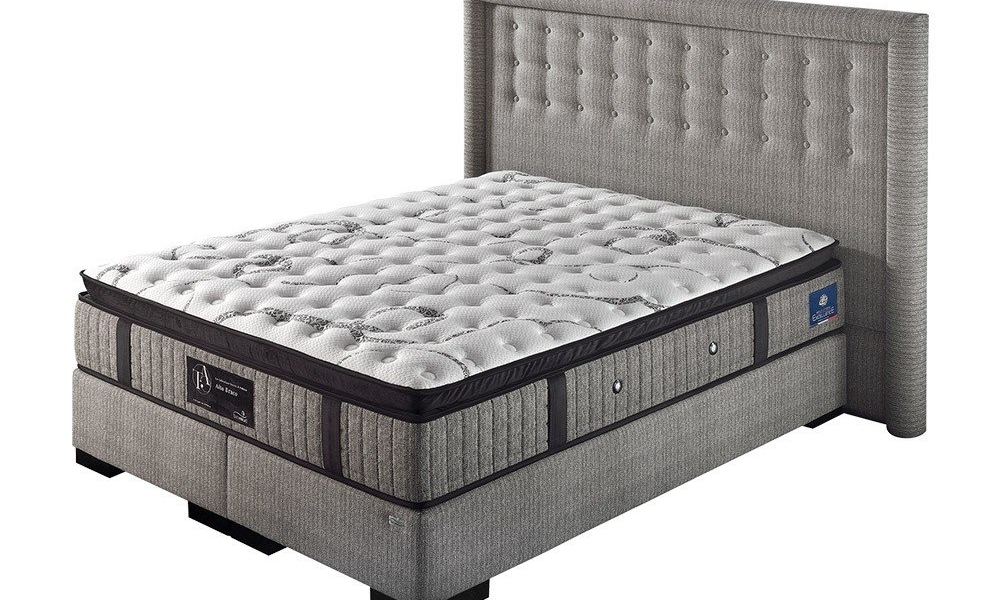 Un lit rembourré gris avec une tête de lit capitonnée et un matelas à motifs blancs offre une qualité exceptionnelle, alliant harmonieusement style et confort. Canape Paris by Atelier Bis