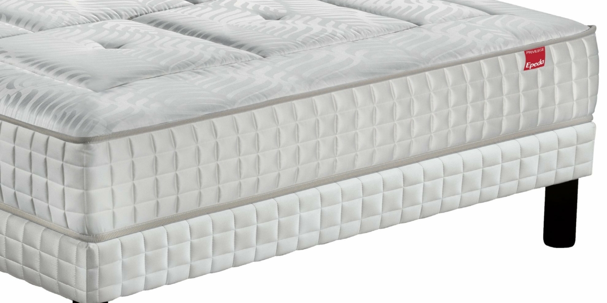 Un matelas blanc au motif texturé repose élégamment sur un cadre de lit aux pieds noirs, rappelant le style parisien chic. Canape Paris by Atelier Bis