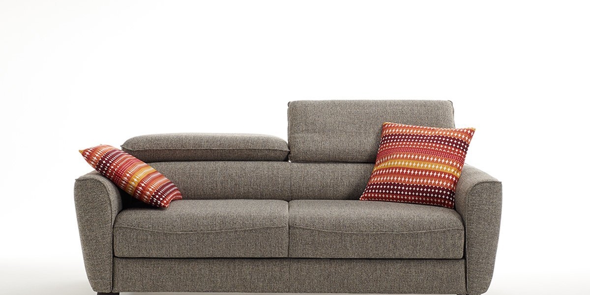 Canapé gris avec deux coussins à rayures colorées à chaque extrémité, sur fond blanc uni, rappelant le style parisien chic. Canape Paris by Atelier Bis