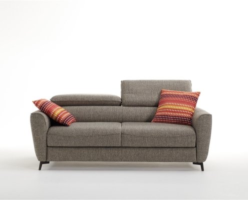 Canapé gris avec deux coussins à rayures colorées à chaque extrémité, sur fond blanc uni, rappelant le style parisien chic. Canape Paris by Atelier Bis