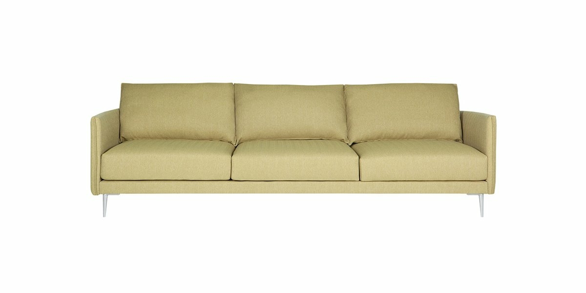 Un canapé minimaliste vert clair avec trois coussins et des pieds fins se dresse élégamment sur un fond blanc, dégageant une touche parisienne chic. Canape Paris by Atelier Bis