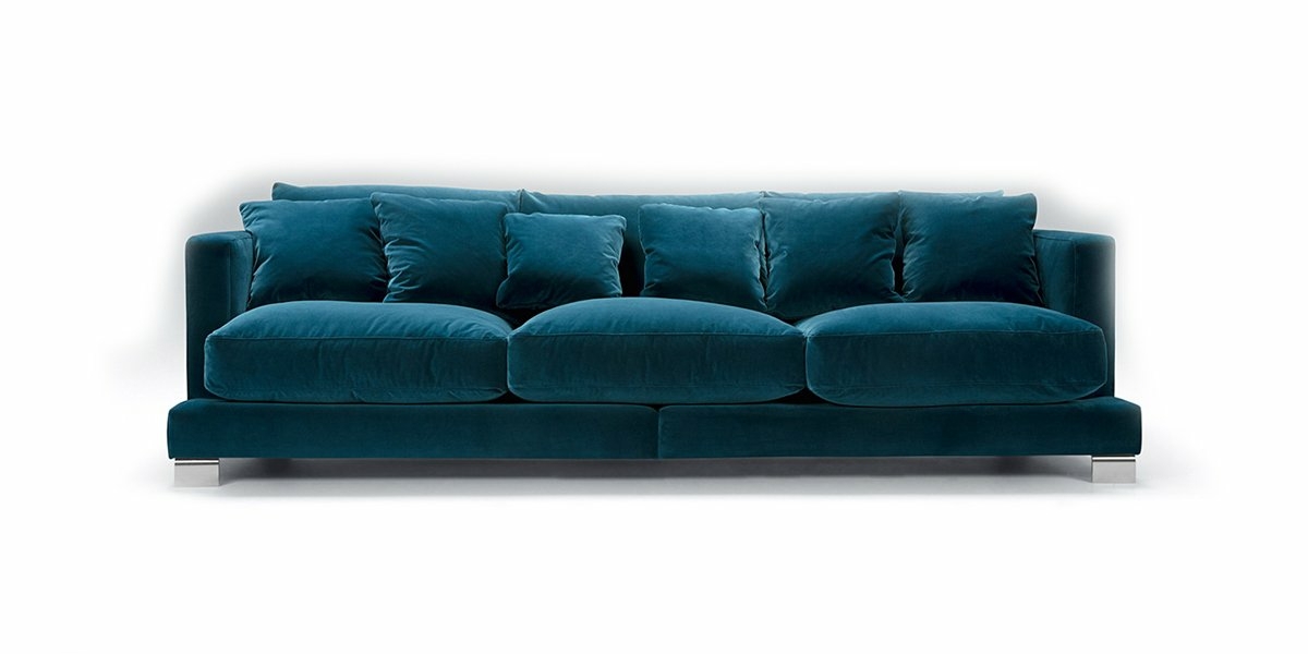 Le canapé en velours bleu sarcelle avec des coussins moelleux capture l'élégance parisienne sur un fond blanc. Canape Paris by Atelier Bis