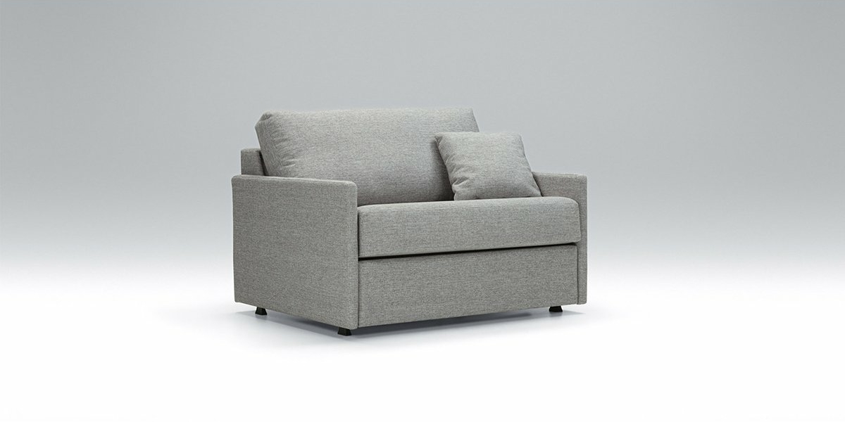 Fauteuil gris avec un coussin gris assorti, rappelant l'élégance parisienne, sur fond gris clair uni. Canape Paris by Atelier Bis