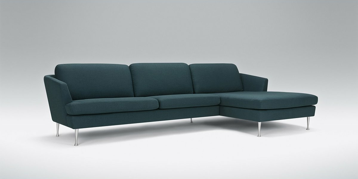 Découvrez le canapé moderne en L bleu sarcelle foncé avec trois sièges et des pieds en métal élégants, présenté dans notre salle d'exposition sur un fond gris clair. Faites l'expérience d'une qualité et d'une élégance inégalées en transformant votre espace de vie. Canape Paris by Atelier Bis