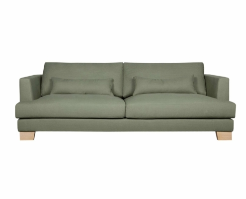 Canapé vert moderne avec pieds en bois, agrémenté de deux grands coussins et de deux petits coussins rectangulaires. Parfait pour un salon à thème parisien ou pour une exposition dans un showroom chic. Canape Paris by Atelier Bis