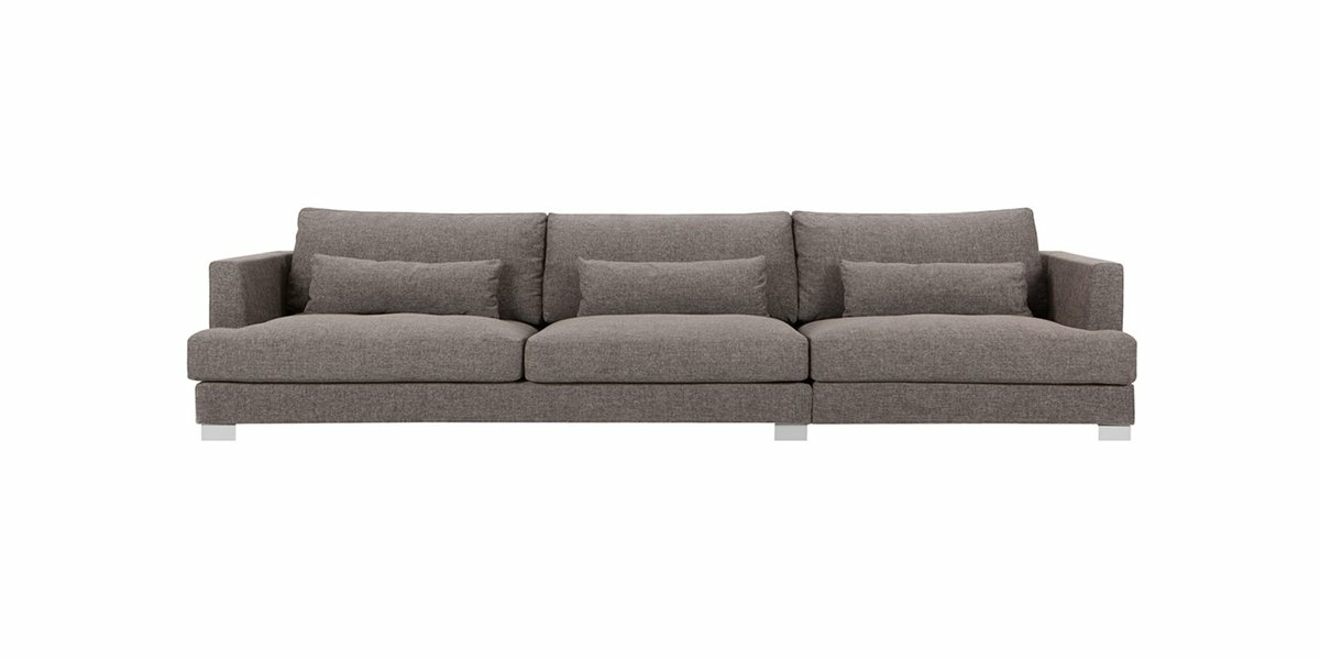 Élégant canapé gris trois places avec accoudoirs carrés, accompagné de quatre coussins assortis, sur fond blanc immaculé. Canape Paris by Atelier Bis