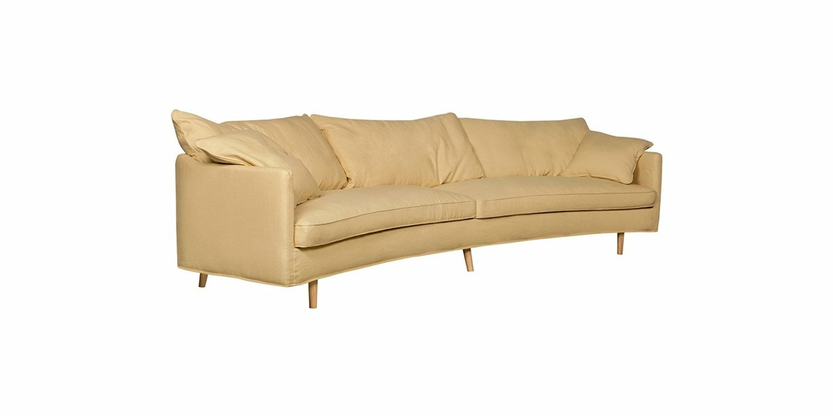 Un canapé trois places courbé beige clair avec des pieds en bois et des coussins moelleux, offrant une excellente qualité et un style rappelant l'élégance parisienne. Canape Paris by Atelier Bis