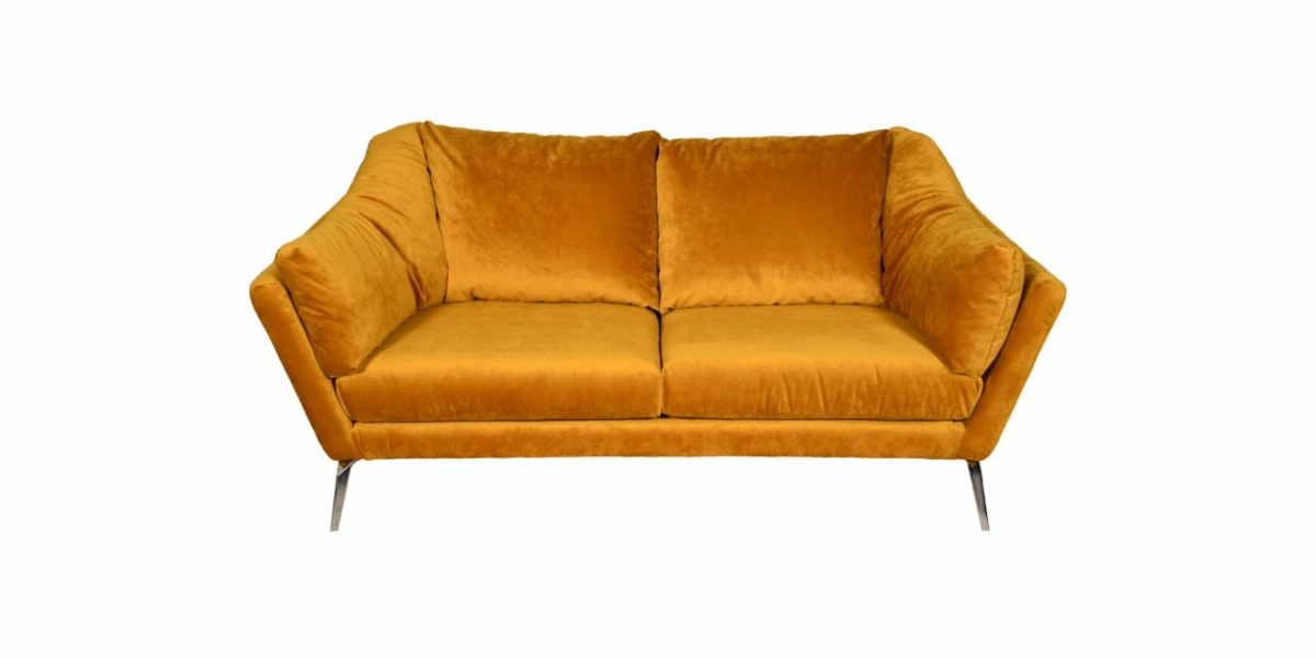 Un canapé deux places en velours jaune moutarde, rappelant une pièce d'exposition parisienne chic, présente des accoudoirs inclinés et des pieds en métal minces sur un fond blanc immaculé. Canape Paris by Atelier Bis