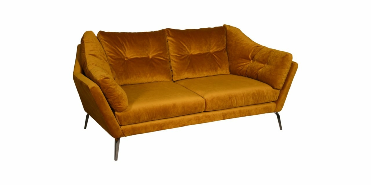 Un canapé en velours jaune moutarde avec des pieds en métal élégants se dresse élégamment sur un fond blanc immaculé, incarnant une sophistication digne d'une salle d'exposition. Canape Paris by Atelier Bis