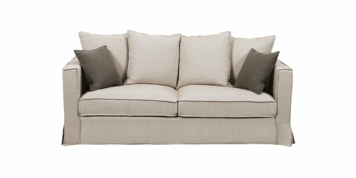 Canapé trois places beige avec deux coussins gris présenté dans notre salle d'exposition sur un fond blanc immaculé, illustrant une qualité exceptionnelle. Canape Paris by Atelier Bis