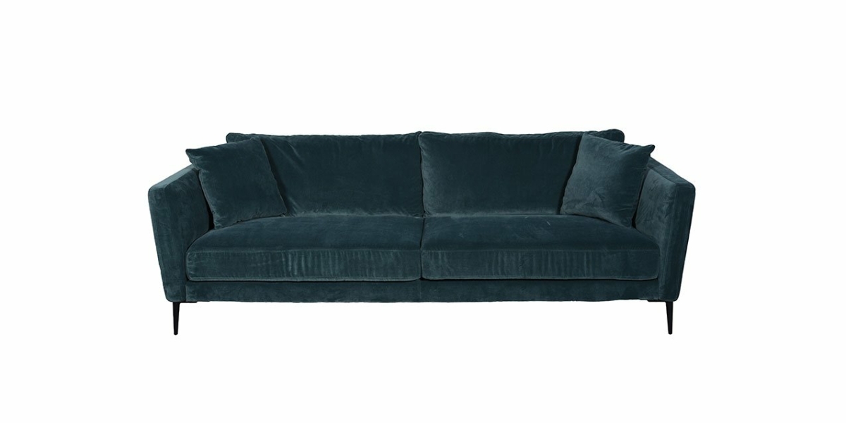Canapé en velours vert foncé avec deux coussins d'assise et des coussins de dossier assortis, agrémenté de quatre coussins décoratifs. Parfait pour une présentation chic dans une salle d'exposition. Canape Paris by Atelier Bis