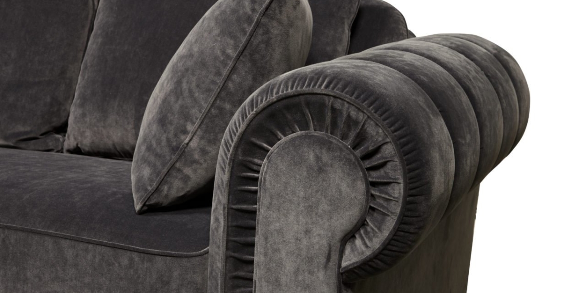 Gros plan d'un canapé en peluche gris foncé avec un accoudoir décoratif et un coussin, mettant en valeur la qualité parisienne. Canape Paris by Atelier Bis