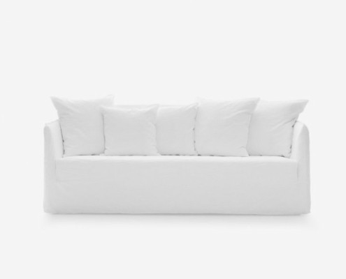 Un canapé blanc minimaliste avec cinq coussins assortis respire la qualité sur un fond uni. Canape Paris by Atelier Bis