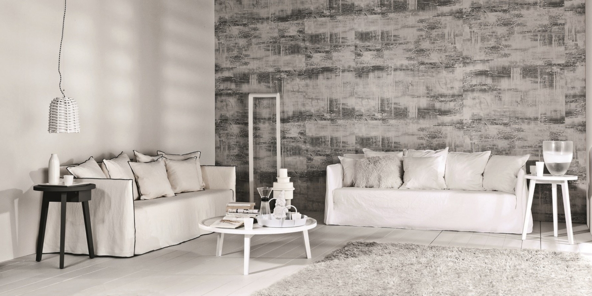 Une touche d'élégance parisienne imprègne ce salon minimaliste, doté de deux canapés blancs, d'une table basse ronde, d'un mur d'accent gris texturé et d'un tapis gris. Découvrez une qualité supérieure dans chaque détail. Canape Paris by Atelier Bis