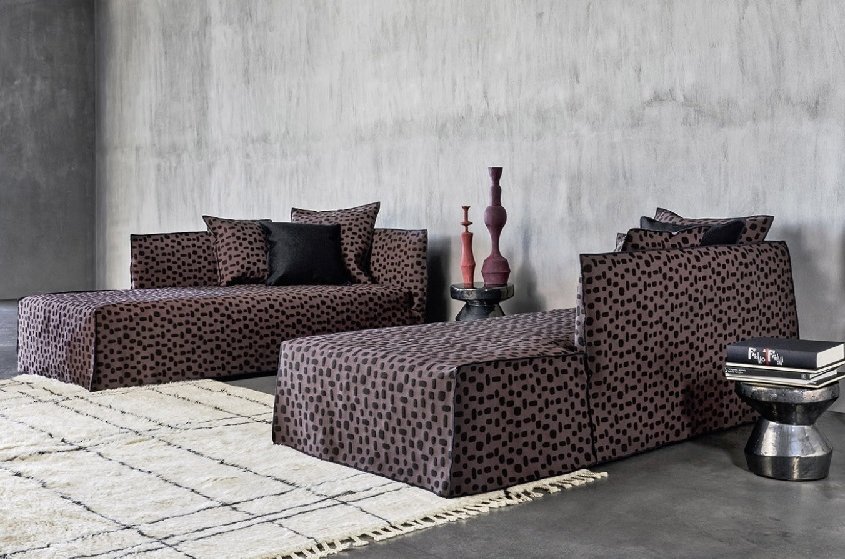 Salon moderne avec des canapés à motifs de haute qualité, des vases abstraits, une œuvre d'art circulaire et un tapis géométrique chic. Canape Paris by Atelier Bis