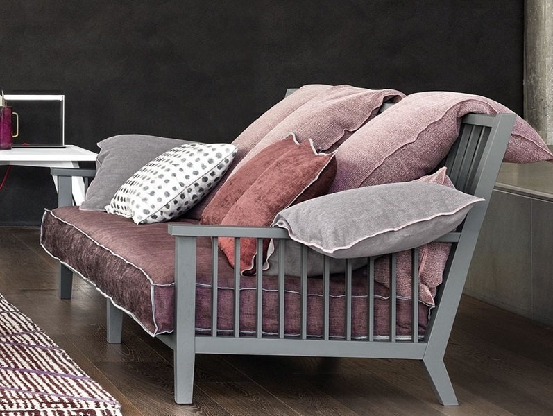 Découvrez notre canapé moderne, présenté dans notre showroom, composé de multiples coussins aux tons de rose et de gris sur un plancher en bois, accompagné d'une table d'appoint chic. Faites l'expérience d'une qualité et d'un style inégalés qui offrent un excellent rapport qualité-prix. Canape Paris by Atelier Bis