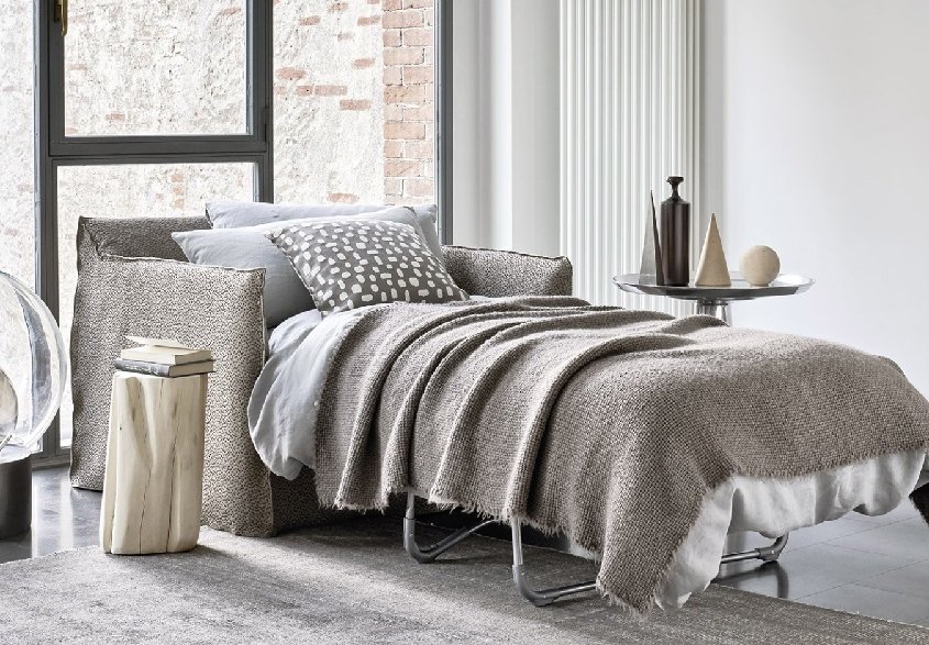 Chambre contemporaine avec un lit douillet, des tons neutres et une table d'appoint, conçue avec des détails de qualité showroom. La grande fenêtre offre une vue rafraîchissante sur la verdure. Canape Paris by Atelier Bis