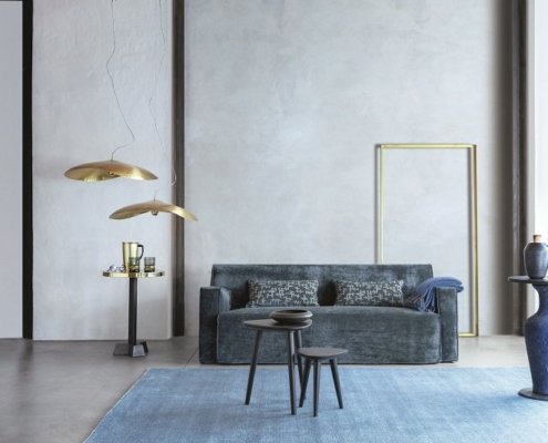 Entrez dans ce showroom élégant doté d'un salon moderne, où un canapé bleu occupe le devant de la scène. Les tables basses sont parfaitement associées à des lampes suspendues et des vases décoratifs sur pied, le tout illustrant une qualité exceptionnelle. Canape Paris by Atelier Bis