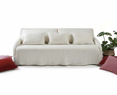 Découvrez l'élégance d'un canapé blanc orné de coussins moelleux, entouré de coussins rouges et roses vibrants, à côté d'une plante en pot luxuriante. Témoignage de la qualité parisienne, il respire le charme et la sophistication sur un fond blanc immaculé. Canape Paris by Atelier Bis