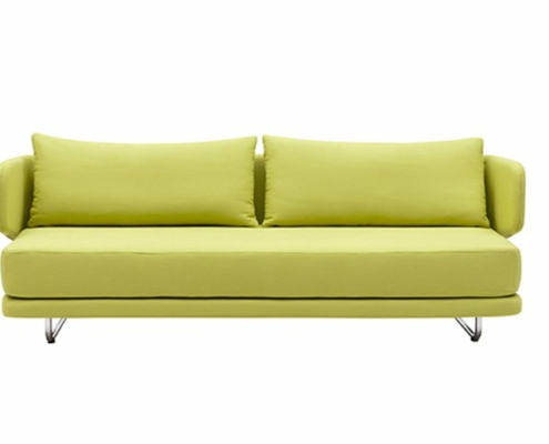 Un canapé vert citron avec deux coussins sur des pieds en métal élégants et modernes, posés sur un fond blanc, offre une qualité exceptionnelle. Canape Paris by Atelier Bis