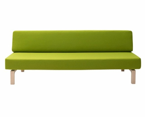 Canapé vert minimaliste avec un cadre en bois simple élégamment présenté dans un cadre de salle d'exposition immaculé. Canape Paris by Atelier Bis