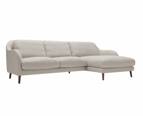 Canapé beige en forme de L avec coins arrondis et pieds en bois, reflétant la qualité d'une salle d'exposition sur un fond blanc immaculé. Canape Paris by Atelier Bis