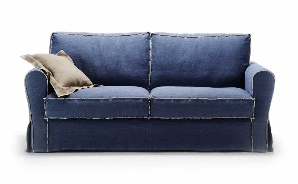 Un canapé deux places bleu avec un passepoil beige exquis et un coussin beige moelleux sur le côté gauche, incarnant l'élégance intemporelle et la qualité que l'on peut s'attendre à trouver dans un appartement parisien chic. Canape Paris by Atelier Bis