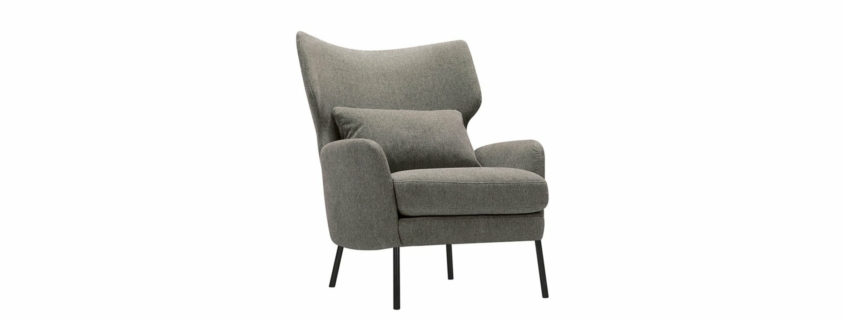 Un fauteuil gris moderne avec un dossier incurvé, des pieds noirs et un coussin assorti sur l'assise, parfait pour ajouter une touche d'élégance parisienne à votre salon ou showroom. Canape Paris by Atelier Bis
