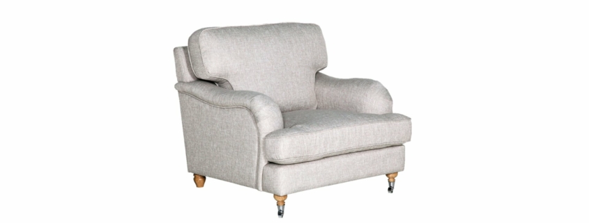 Un fauteuil rembourré gris clair avec des pieds en bois et de petites roulettes, rappelant un showroom parisien chic, se dresse élégamment sur un fond blanc. Canape Paris by Atelier Bis