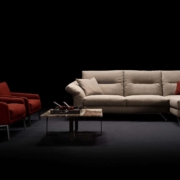 Faites l'expérience d'une qualité inégalée avec notre canapé sectionnel beige, complété par deux fauteuils rouges saisissants et une table basse en verre élégante, le tout élégamment présenté sur un fond sombre sophistiqué, comme s'il sortait tout droit d'un showroom parisien. Canape Paris by Atelier Bis