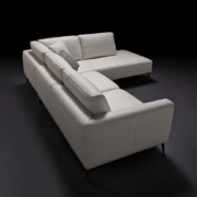 Un canapé sectionnel gris élégant et moderne avec des pieds noirs sur un fond sombre, accentué par plusieurs coussins moelleux. Canape Paris by Atelier Bis