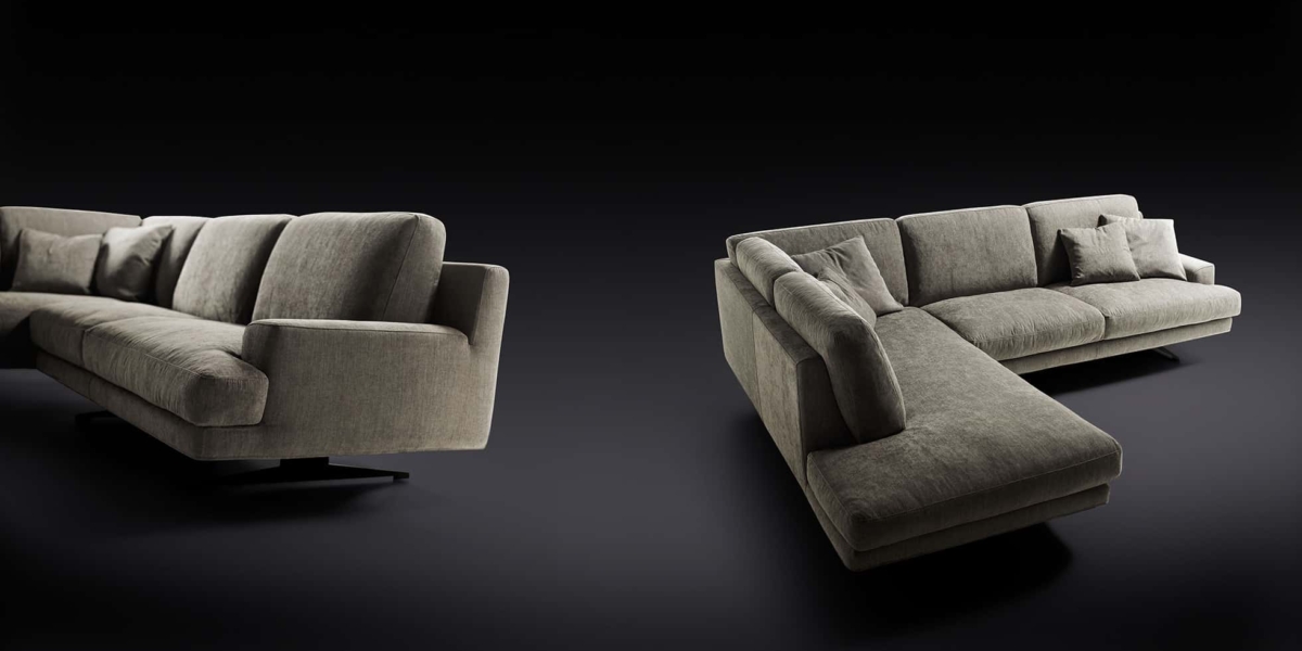 Un design moderne est mis en valeur avec deux canapés sectionnels gris foncé, ou canapé, ornés de coussins sur fond noir, rappelant un showroom parisien chic. Canape Paris by Atelier Bis