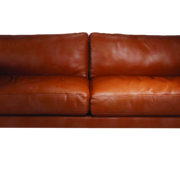 Un canapé en cuir marron avec deux coussins assortis sur fond blanc, offrant un mélange impressionnant de prix et de qualité. Canape Paris by Atelier Bis