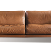 Découvrez l'élégant canapé en cuir marron doté de deux grands coussins et de pieds noirs élégants, parfait pour votre salon d'inspiration parisienne ou votre showroom chic. Canape Paris by Atelier Bis