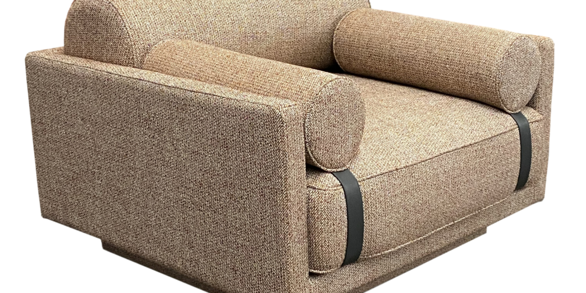 Un fauteuil beige texturé avec des coussins cylindriques et des accents de sangles noires sur les accoudoirs est parfait pour n'importe quelle salle d'exposition. Canape Paris by Atelier Bis