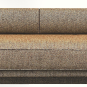 Canapé rembourré marron avec un coussin cylindrique, présentant un design minimaliste qui ne manquera pas de se démarquer dans n'importe quelle salle d'exposition. Canape Paris by Atelier Bis