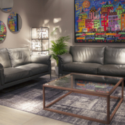 Un salon moderne comprend deux canapés en cuir noir, des œuvres d'art murales colorées, des miroirs ronds et une table basse en verre, où le style rencontre la qualité à un excellent prix. Canape Paris by Atelier Bis